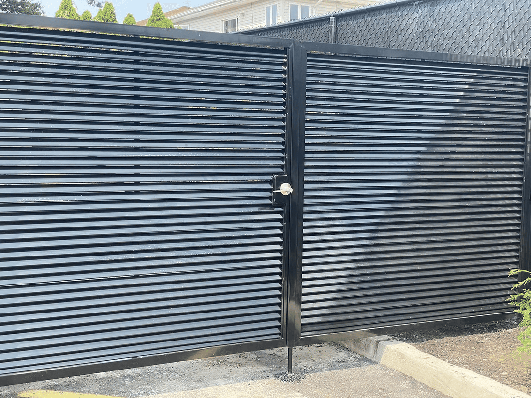 Black horizontal slatted gate with a padlock, leading to a fenced area.