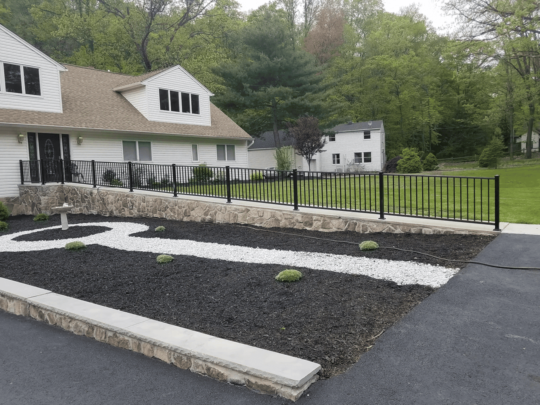 Modern landscape design featuring gravel path and stone border in front of a home.