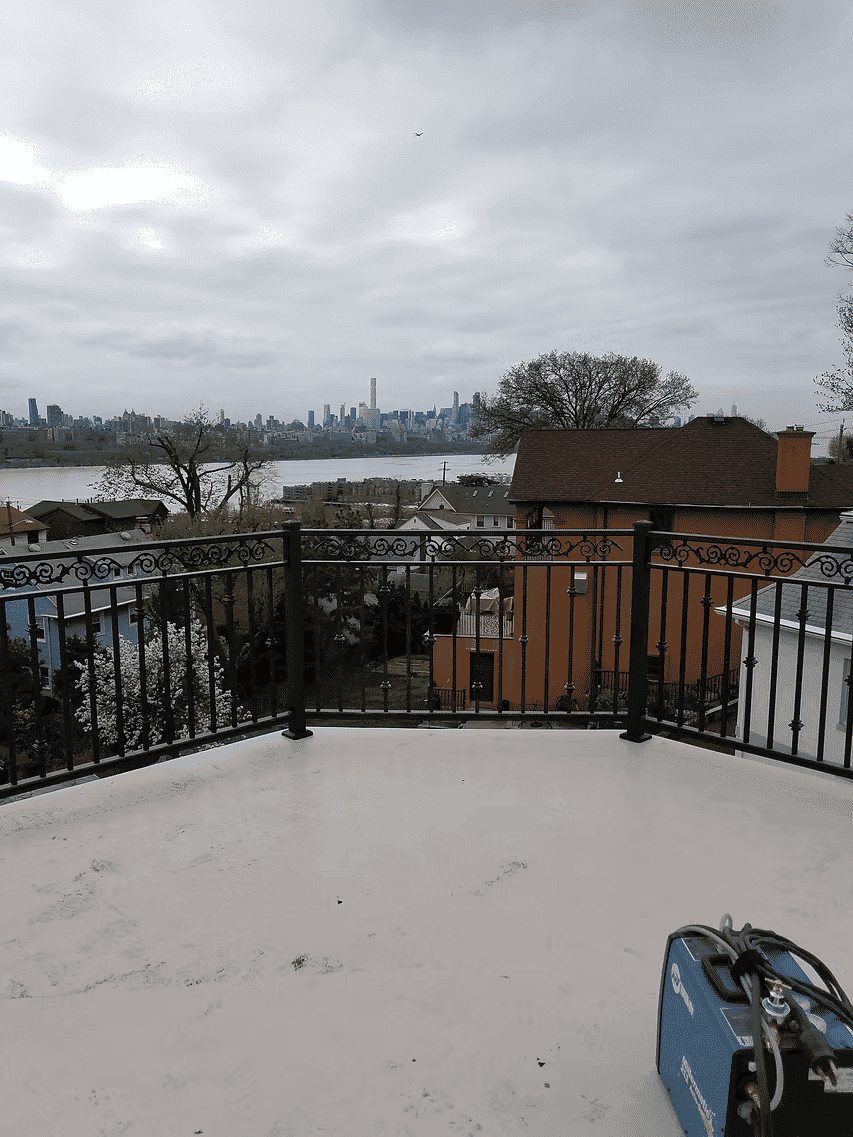 Rooftop view overlooking city skyline and river from a residential balcony.
