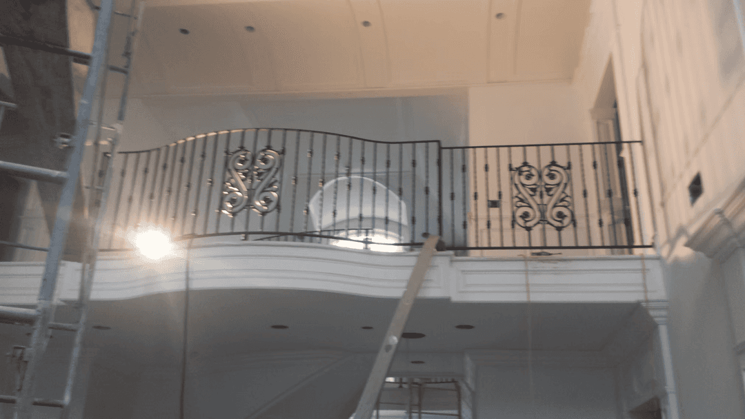 Elegant wrought iron balcony railing in luxurious interior space under construction.