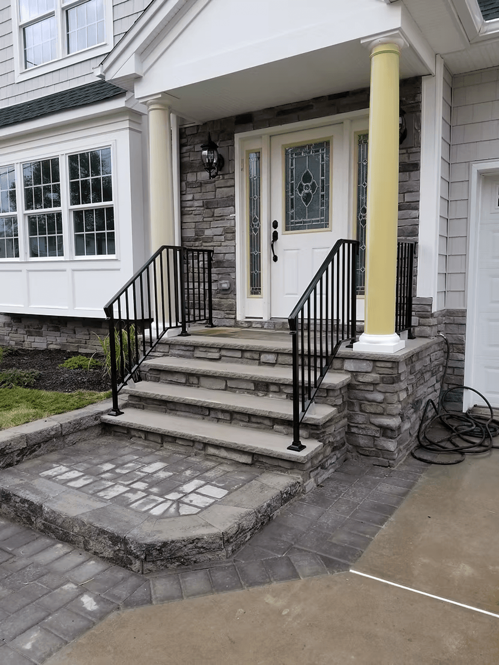 Front entryway featuring elegant stone steps and a double-door entrance with black railings.