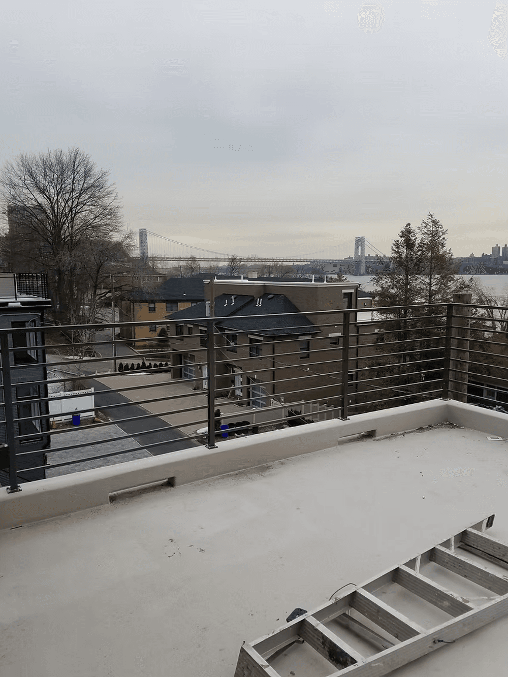 View from a balcony overlooking the George Washington Bridge and residential buildings.