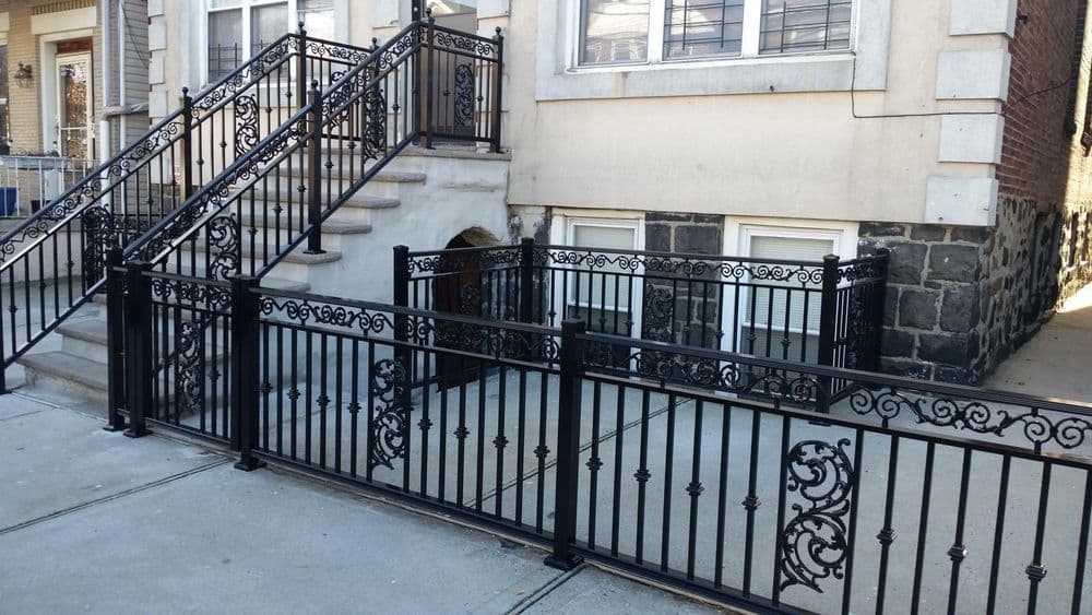 Black wrought iron railings and fences surrounding a staircase and basement entrance.