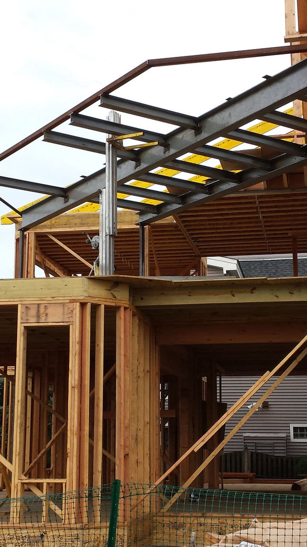 Steel framework and wooden structure of a residential building under construction.