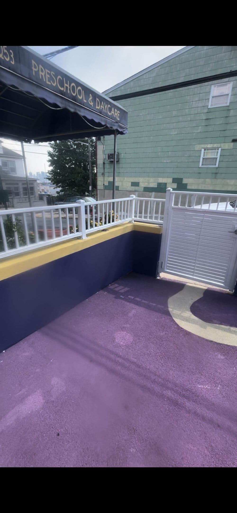 Colorful outdoor play area for a preschool and daycare with a gated entry.