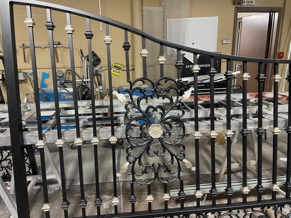 Decorative wrought iron gate with floral design, showcasing craftsmanship and intricate details.