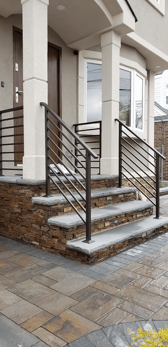 Modern home entrance with stylish metal railings and stone steps.