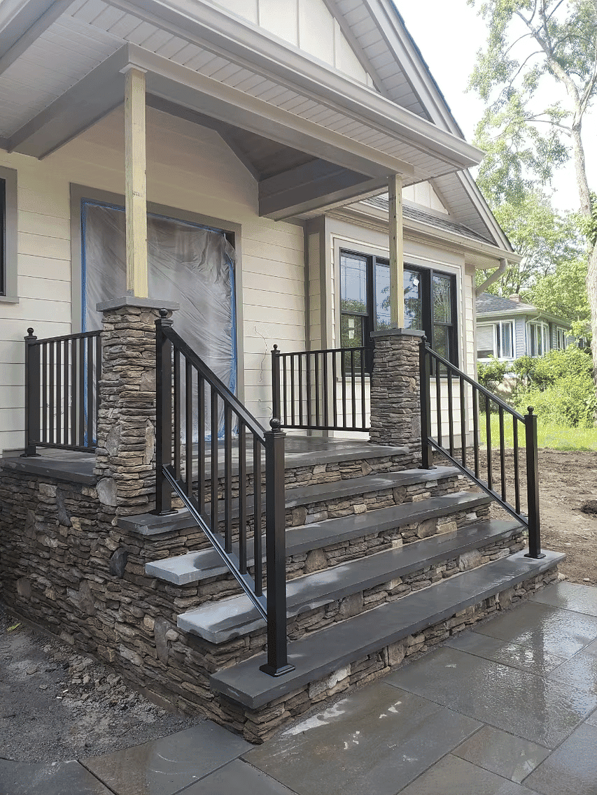 Modern porch with stone steps and black railings, enhancing curb appeal and accessibility.