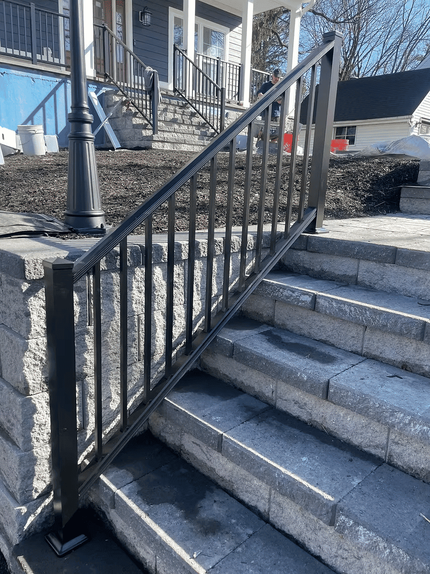 Metal railing on stone steps, enhancing safety and accessibility for home entrance.