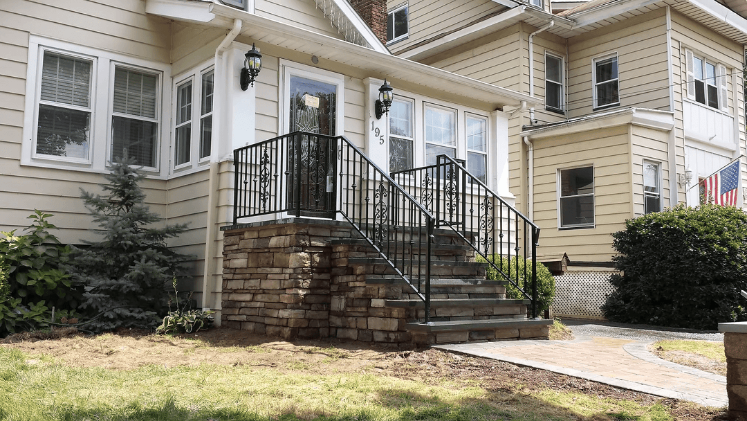 Front entrance with stone steps, decorative railing, and landscaped yard. House number 195 visible.